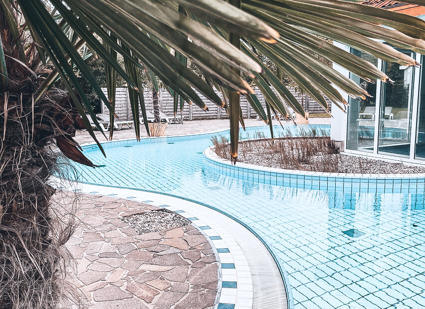 Modern pool area with indoor pool, showers, and sauna